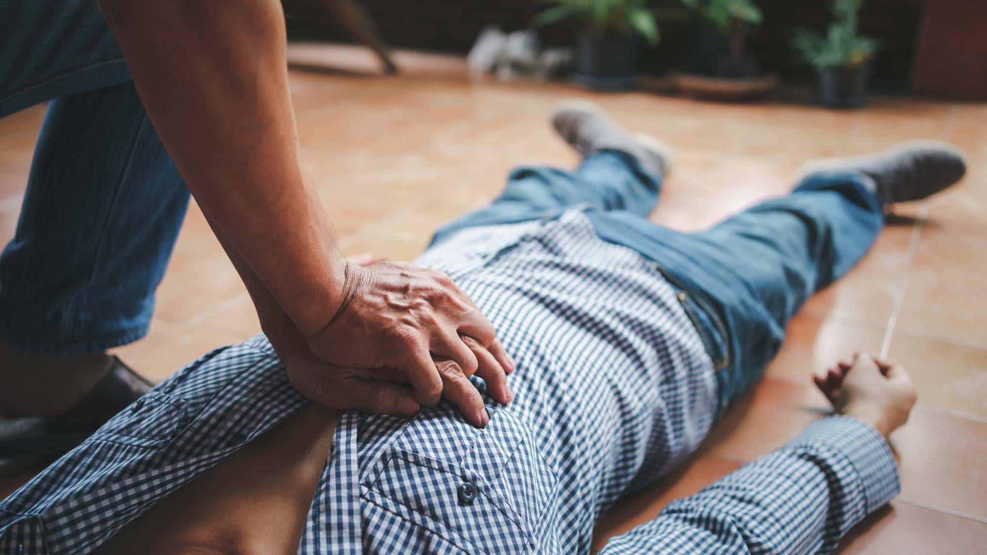 chest compressions being applied to man on floor